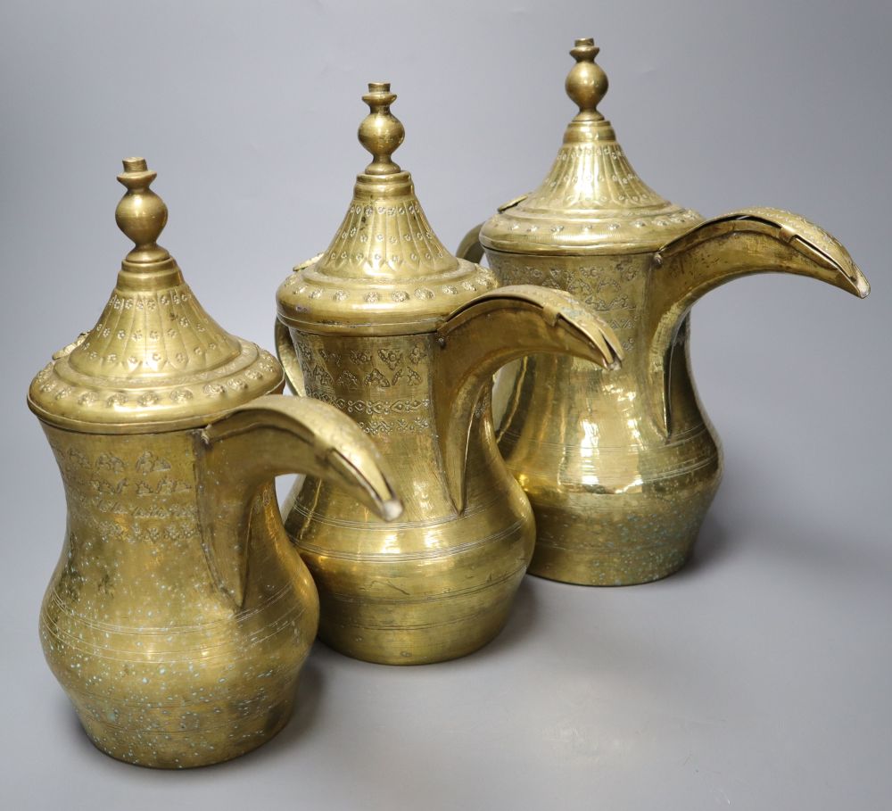 A graduated set of three Arab brass coffee pots (Dallah), tallest 29cm